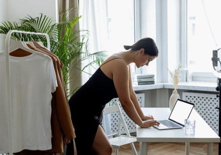 A woman entrepreneur sitting confidently at her desk, representing empowerment and breaking free from limiting beliefs.